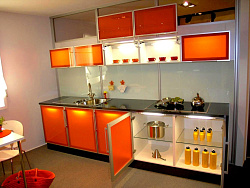 Небольшая кухня с оранжевыми стеклянными фасадами