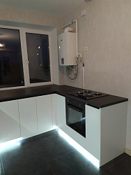Белая кухня с темной столешницей, подсветкой и высокими верхними шкафчиками со скрытыми ручками