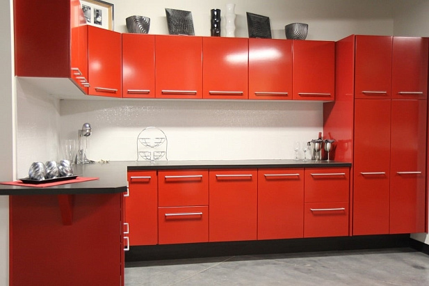 Красная угловая кухня с черной столешницей