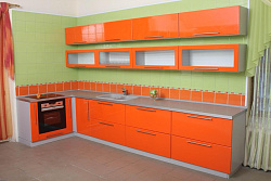 Угловая кухня с оранжевыми фасадами
